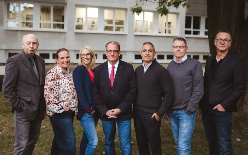 Gruppenbild der sieben Mitglieder der Schulleitung der Gesamtschule Meiderich vor dem Schulgebäude.