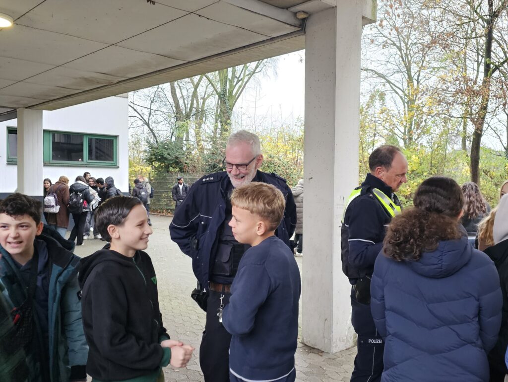 Polizeibeamte im Gespräch mit SchülerINNEN der JAhrgangsstufe 7 der GSM