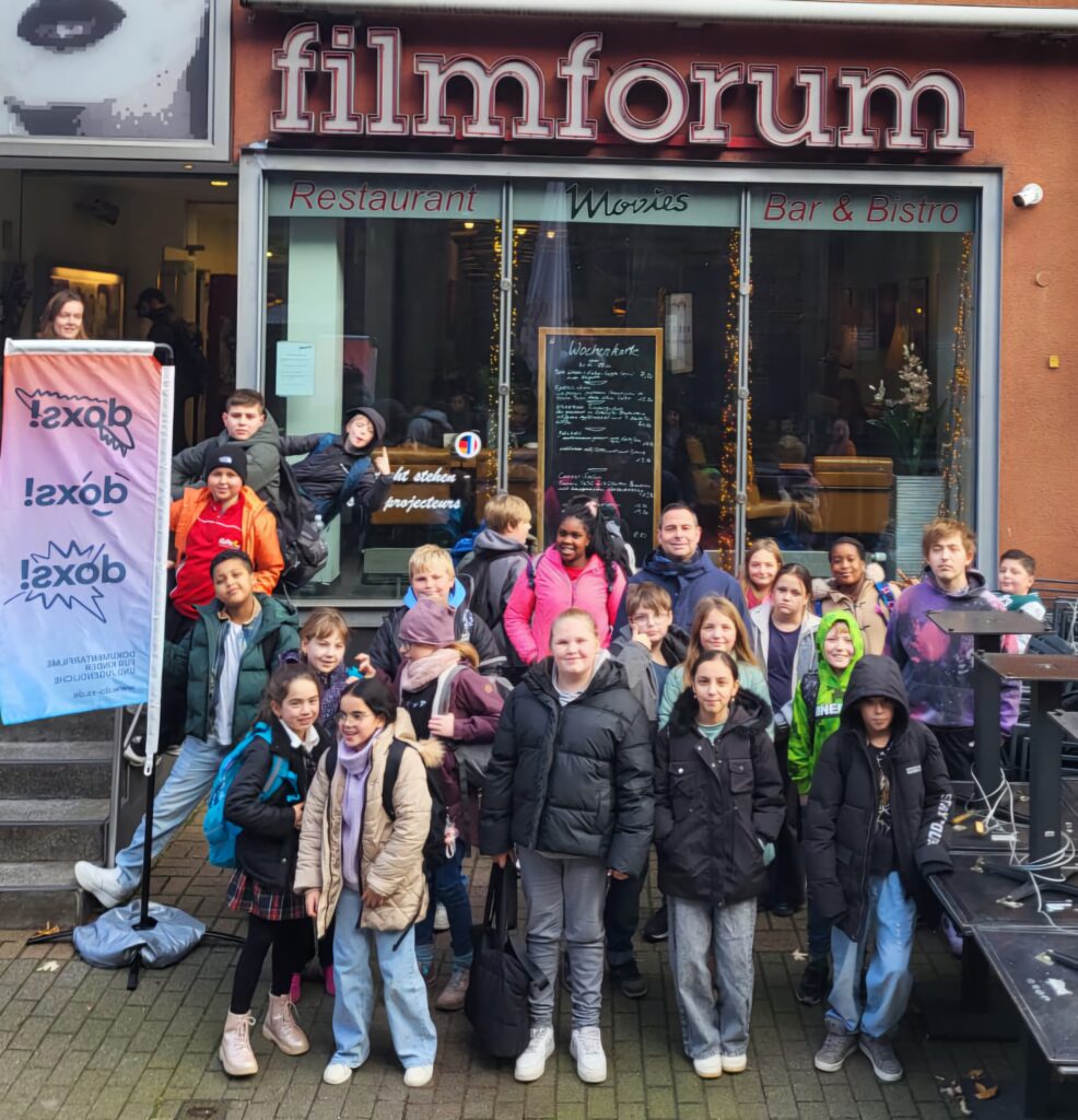 Gruppe von Schülern vor einem Kino.