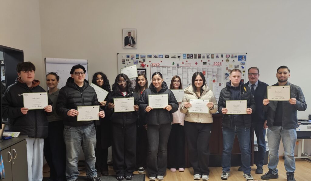 Schüler und Schulleiter der Gesamtschule Meiderich mit Zertifikat im Büro des Schulleiters