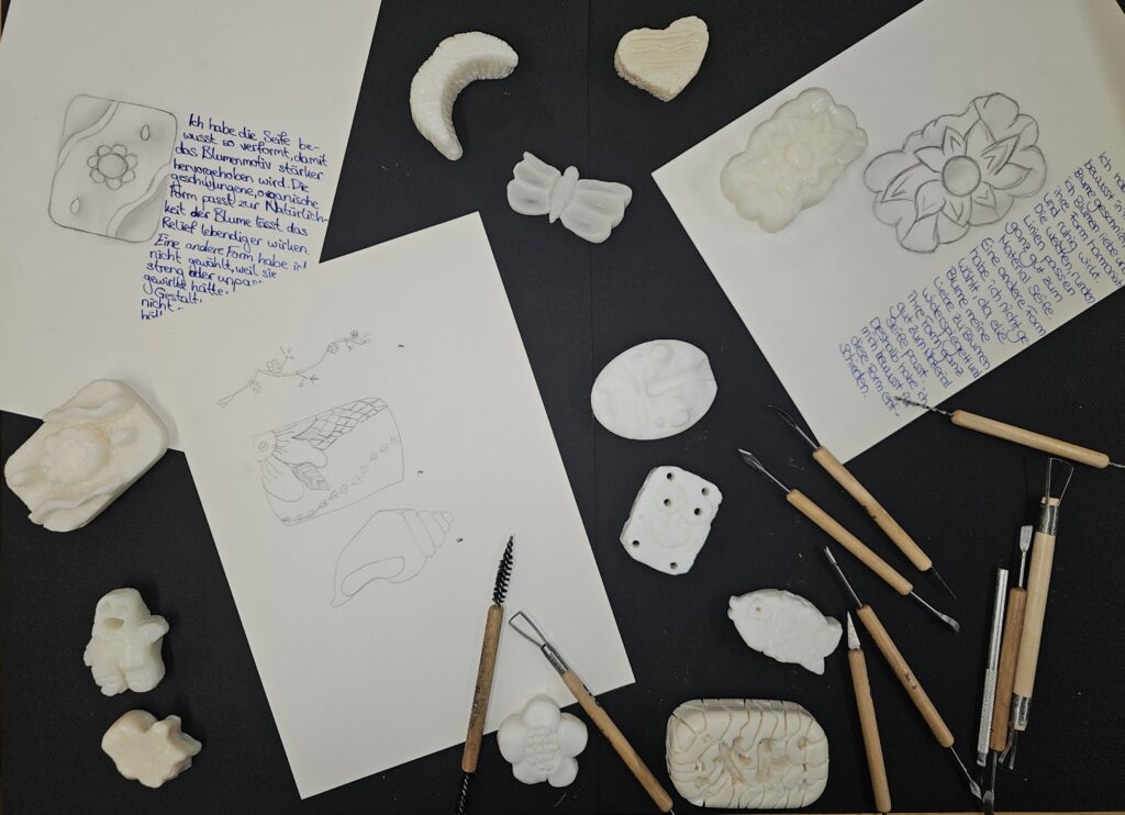 Seifenskulpturen und Vorzeichnungen auf einem Tisch liegend.