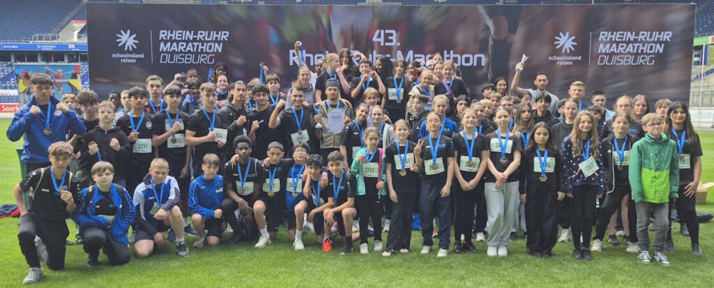 Gruppenbild aller Laufteilnehmer der Gesamtschule Meiderich aus verschiednen Jahrgängen im Stadion